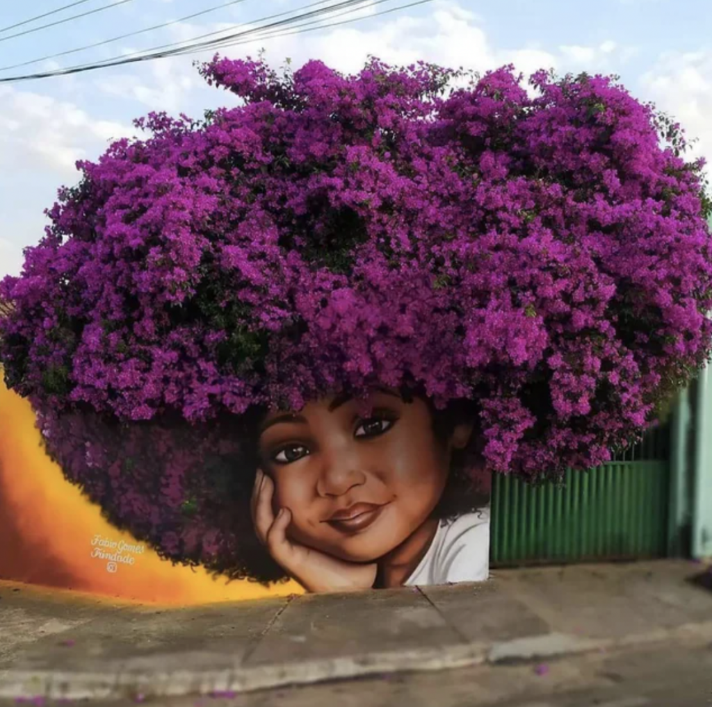 An image of a girl with her head in her hand that's been set up right next to a beautiful bright purple-colored tree.