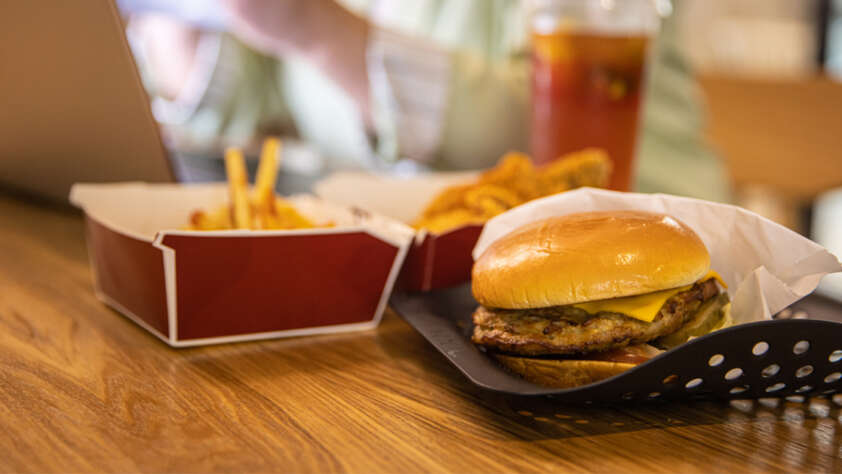 An image of a burger placed next to container of fries.