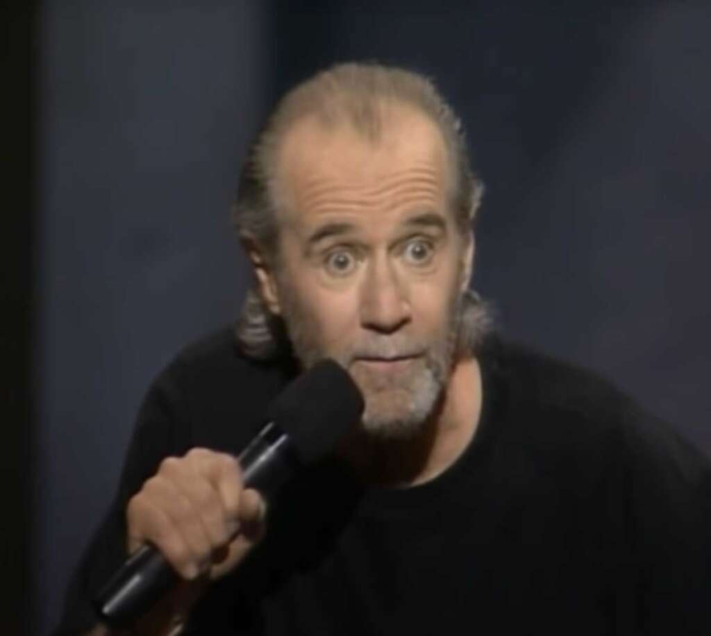 George Carlin staring at the audience while doing standup 