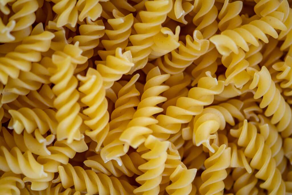 A close-up image of a ton of pasta shells. 