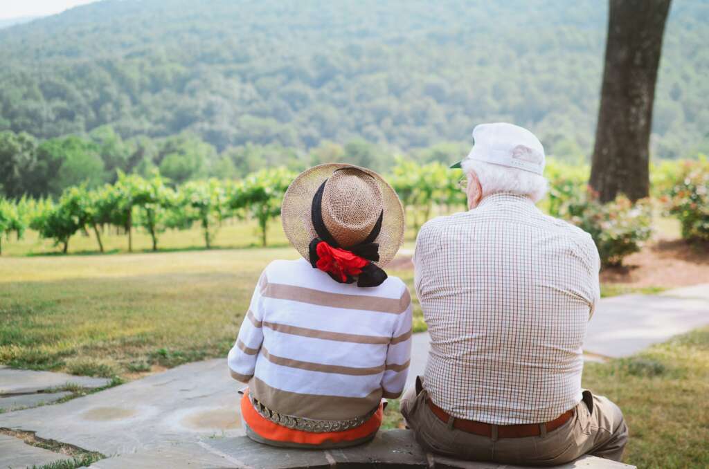 An image of an elderly couple sitting next to each other. 