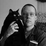 Photo of Colby Droscher holding a black cat