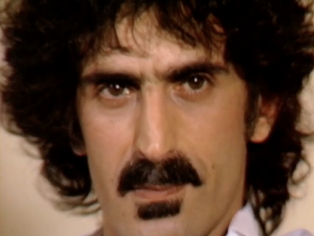 Close shot of Frank Zappa listening to a question during an interview