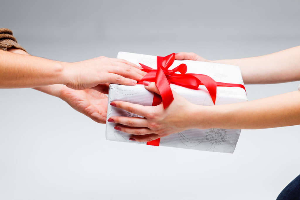 An image of someone receiving a wrapped gift. 