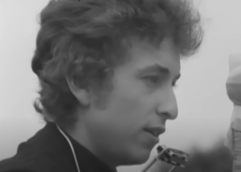 A still image of Bob Dylan in concert. 