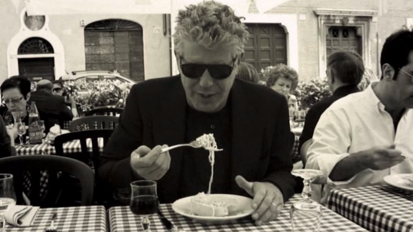 An image of Anthony Bourdain eating pasta.