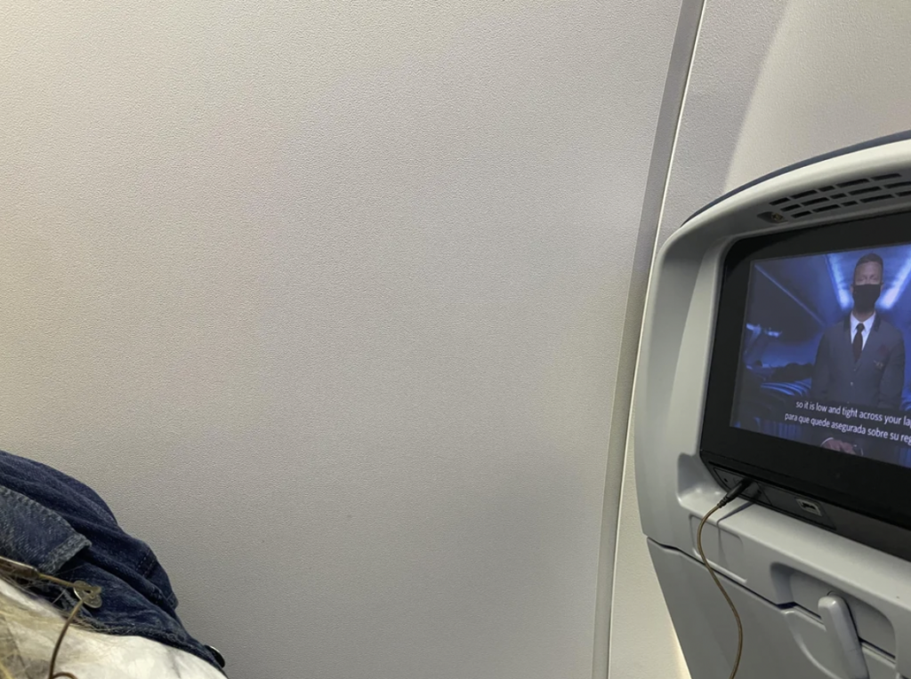 An image of someone on a Delta flight in window seat, with no view outside of the window. 