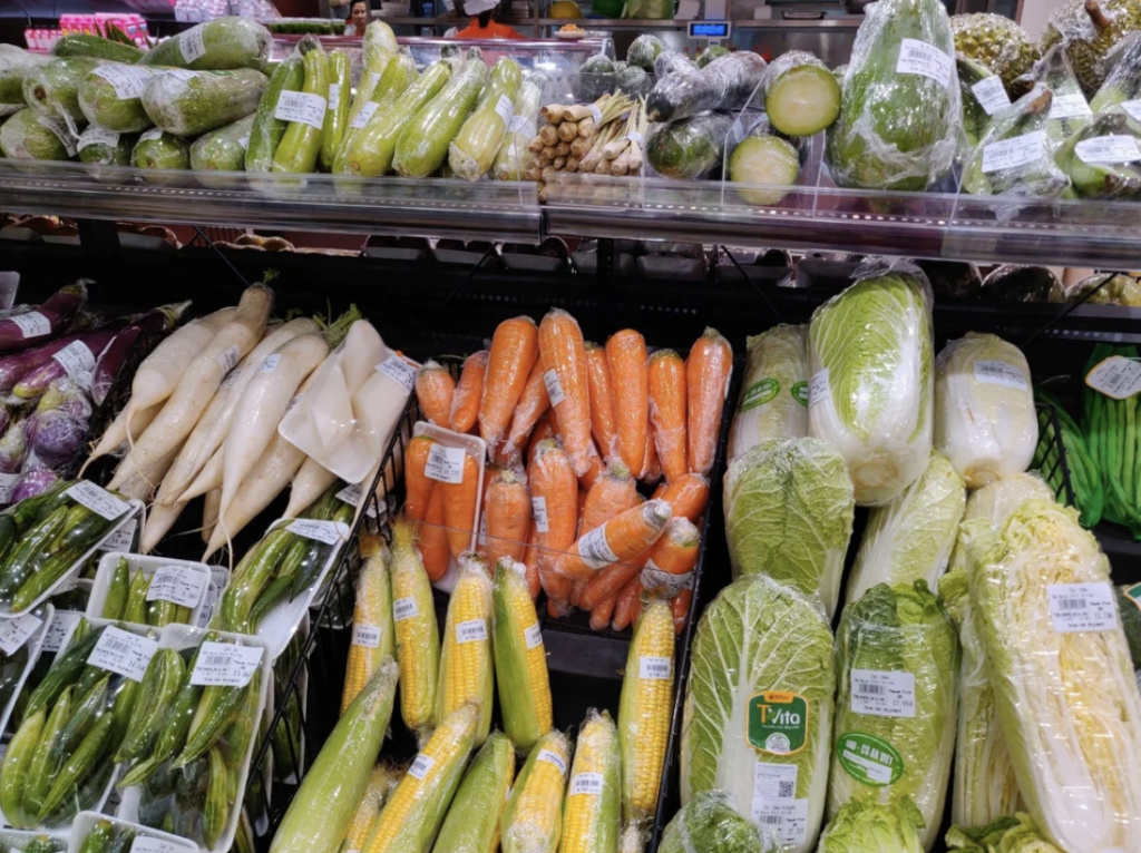 A collection of Vietnamese vegetables that have been individually wrapped in a supermarket. 