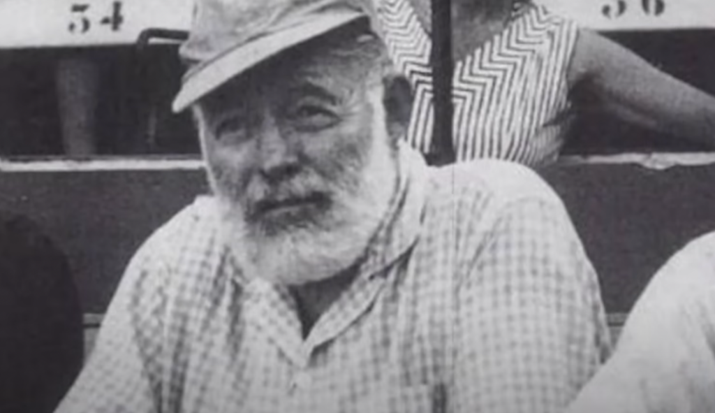 Older Ernest Hemingway with a cap on. 