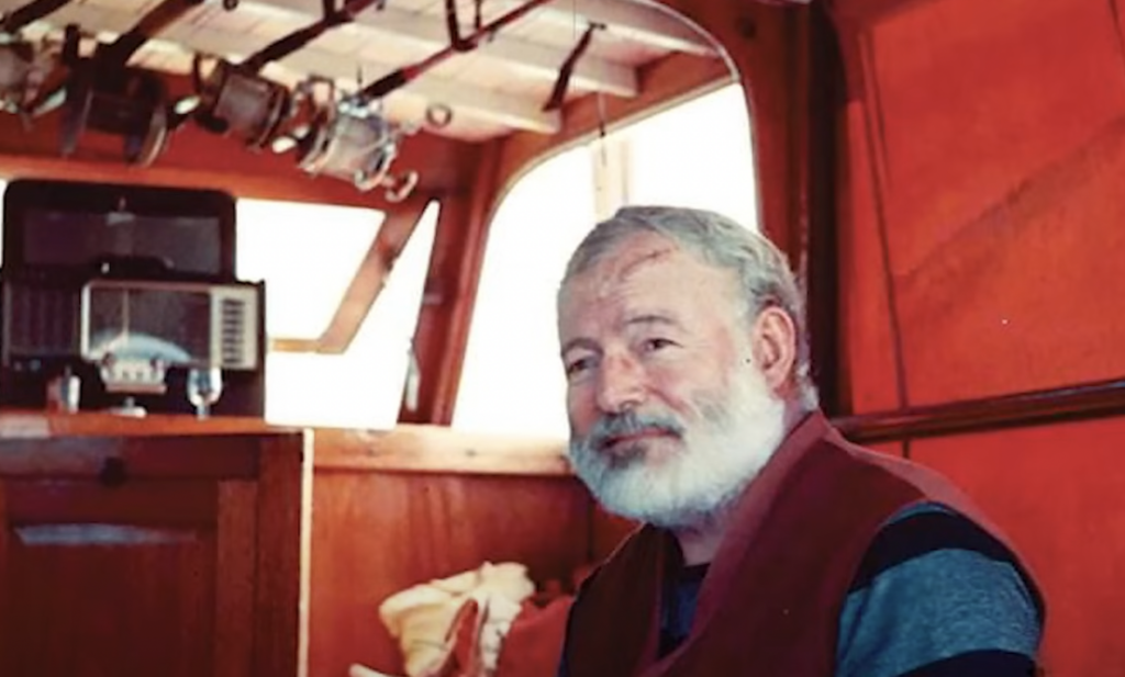 Color photo of Ernest Hemingway in a boat. 