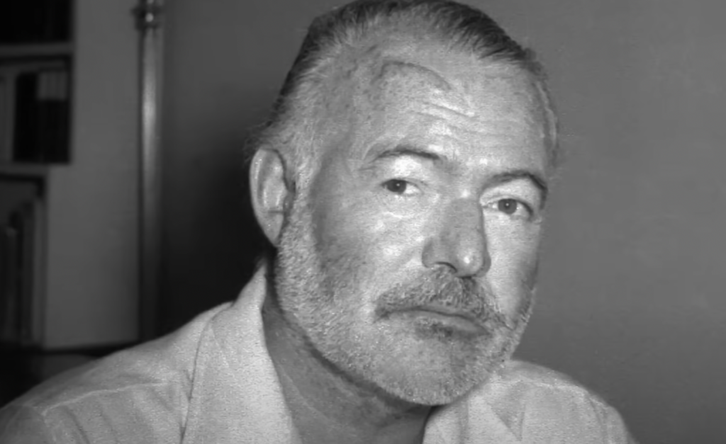Ernest Hemingway stares at the camera. 