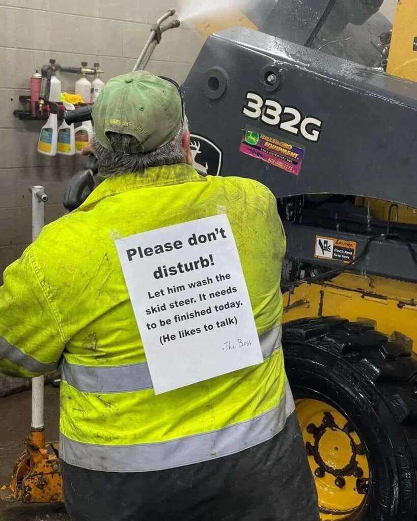 A man working with a sign on his back telling people not to talk to him