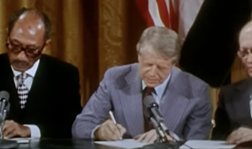 Jimmy Carter signing paper. 