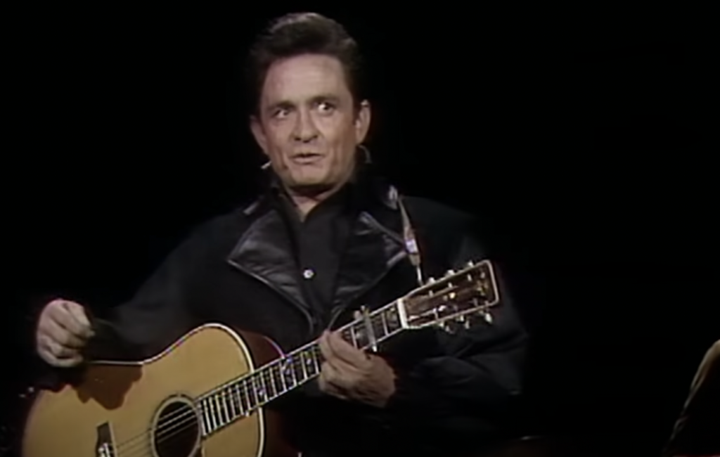 Johnny Cash holding guitar. 