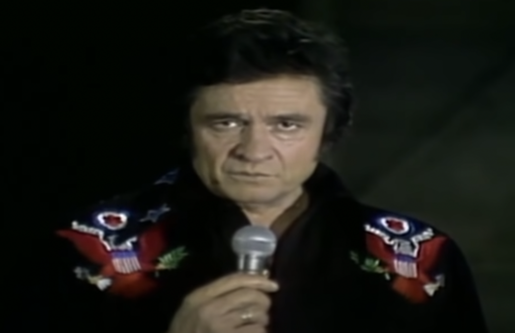Johnny Cash looking seriously into the microphone. 