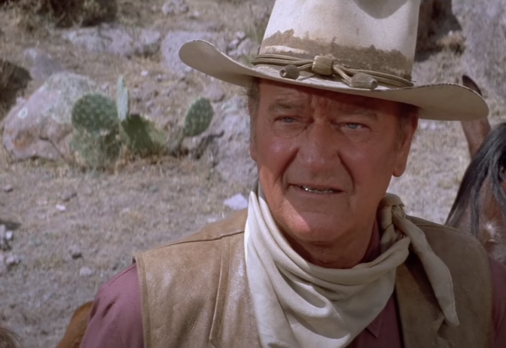 A still image of John Wayne talking. 