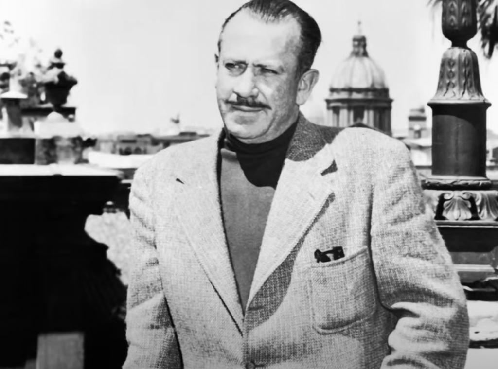 An older John Steinbeck with a mustache in a nice blazer. 