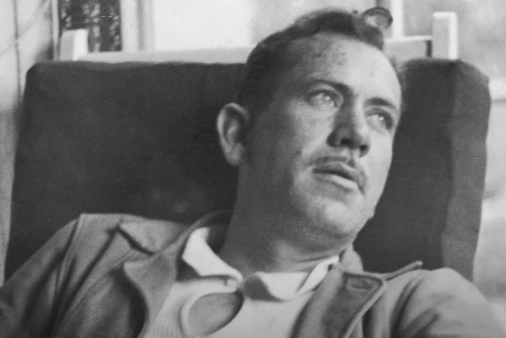 John Steinbeck young in black and white looking off into the distance. 