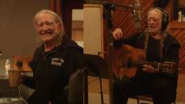 A cover image of Willie Nelson singing in the studio.
