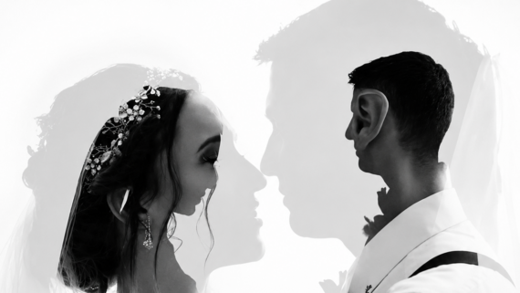 A double exposure image of a bride and groom facing each other, with their profiles overlapping. The bride wears a jeweled headpiece and earrings, while the groom is dressed in a formal shirt and suspenders.
