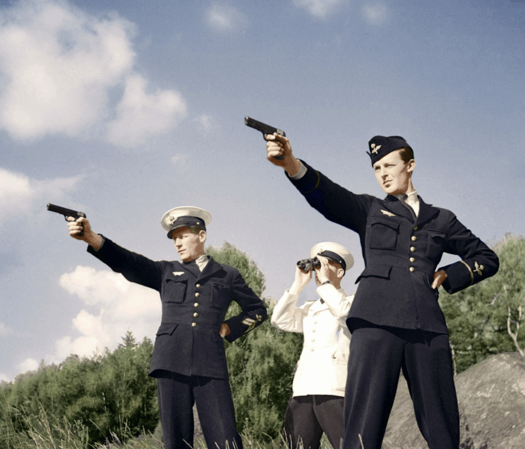 Three uniformed naval officers stand outdoors; two aim pistols forward, while the third, in white, observes through binoculars. Trees and a blue sky with clouds are in the background.