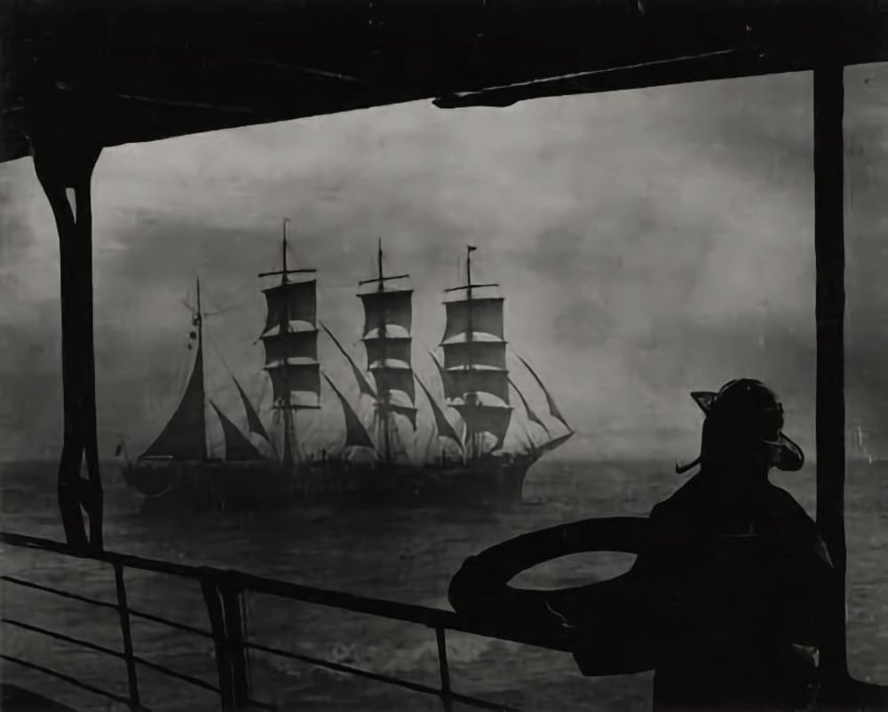 A silhouette of a person on a ship’s deck looks out at a large sailing ship with multiple masts on a misty, dark sea. The scene is moody and atmospheric, suggesting a vintage or historical setting.