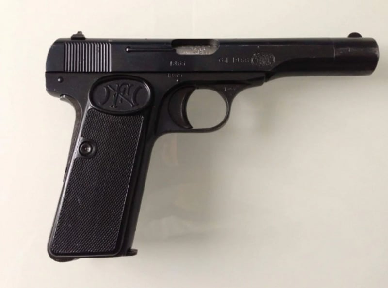 A black semi-automatic pistol with a textured grip and an FN logo on the handle, displayed on a plain light background.