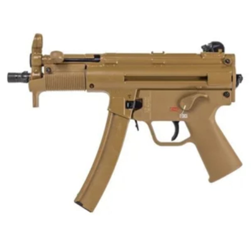 A tan-colored submachine gun with a curved magazine, front and rear sights, and a selector switch above the trigger. The firearm is shown in a side profile against a white background.