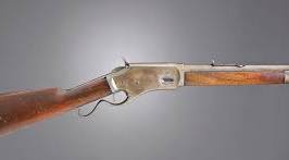 Lever-action rifle with a wooden stock and metal receiver, displayed on a plain gray background.