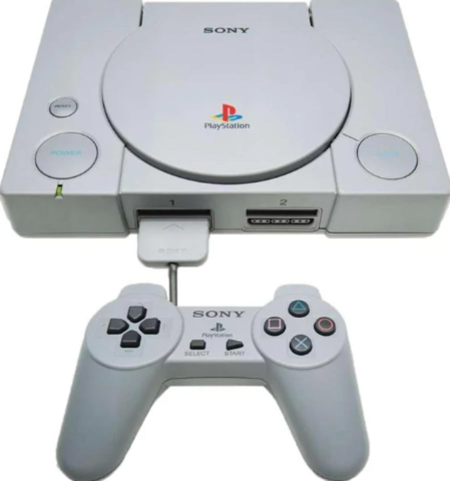 A gray Sony PlayStation console with an open controller port and a wired controller placed below it, displaying the classic four-button layout and PlayStation logo.
