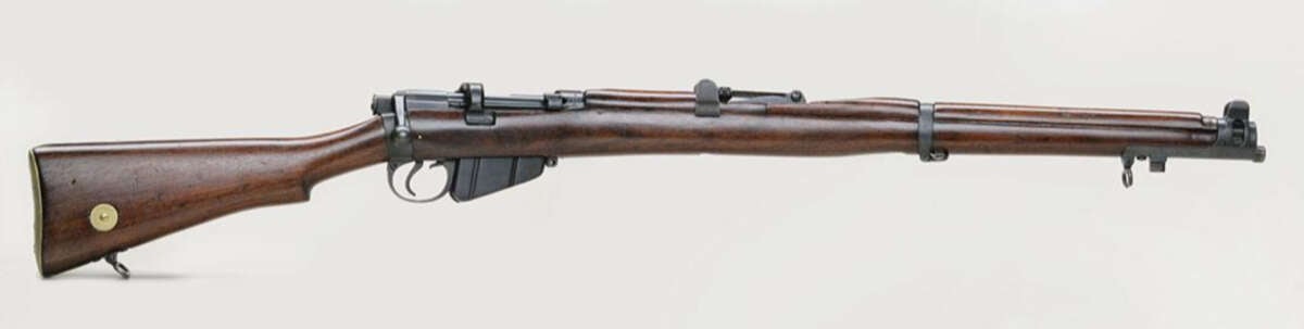 A vintage bolt-action rifle with a wooden stock and metal barrel, featuring iron sights and a magazine beneath the receiver, displayed on a plain white background.
