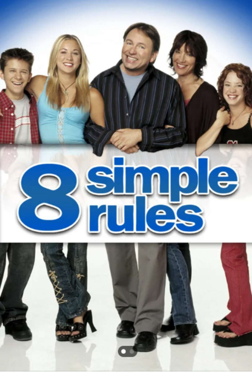 Five smiling people stand together above the "8 Simple Rules" logo on a white background, with only their legs visible below the title. The group appears cheerful and casual.