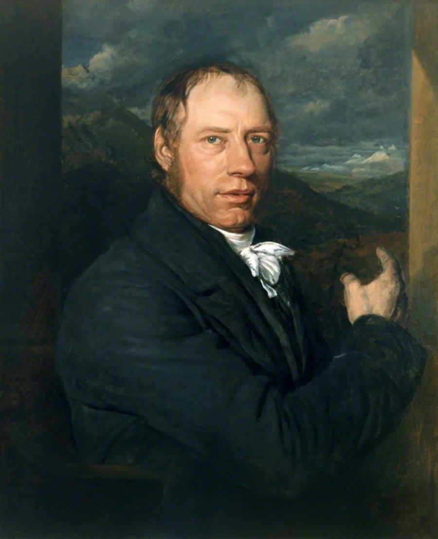 A man in formal 18th-century clothing stands in front of a landscape, facing forward and gesturing with his right hand. He has short brown hair and a serious expression. Dark skies and mountains are visible in the background.