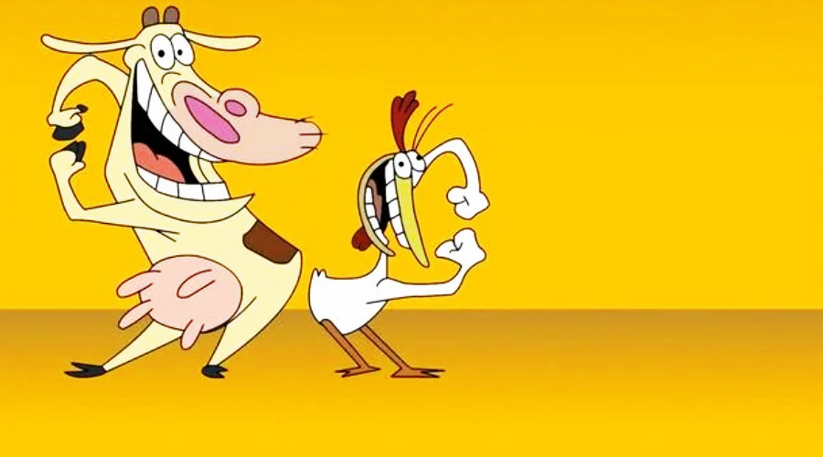 A cartoon cow and a cartoon chicken stand together on a yellow background, both smiling widely with exaggerated expressions. The cow is on the left and the chicken is on the right, both facing forward.