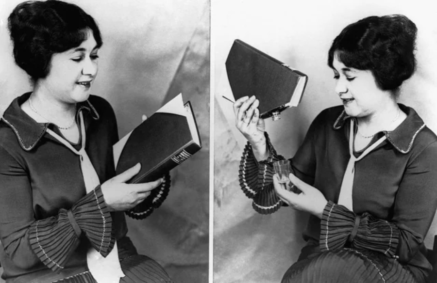 A woman in vintage clothing smiles while holding a book. In the next frame, she opens the book to reveal a hidden compartment containing a small bottle, demonstrating a secret storage book.
