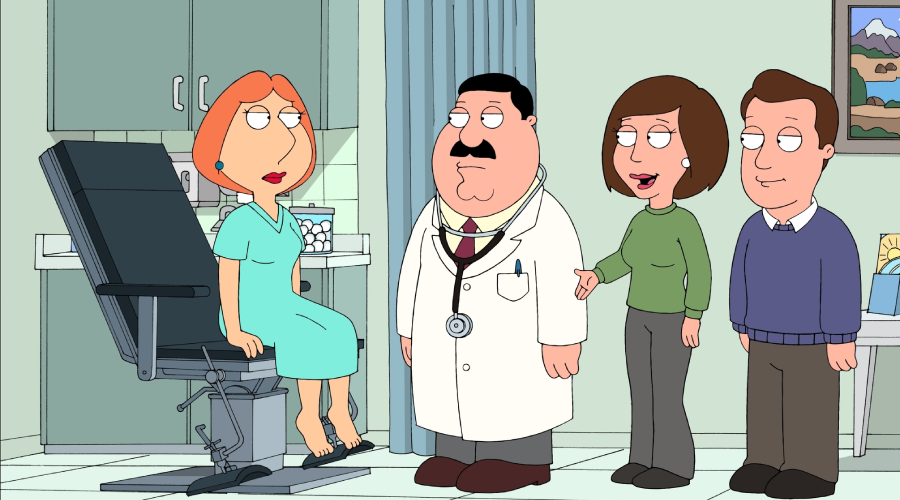 A woman in a hospital gown sits on an exam chair in a doctor's office, facing a doctor with a stethoscope and two people, one woman and one man, standing nearby and talking to her.