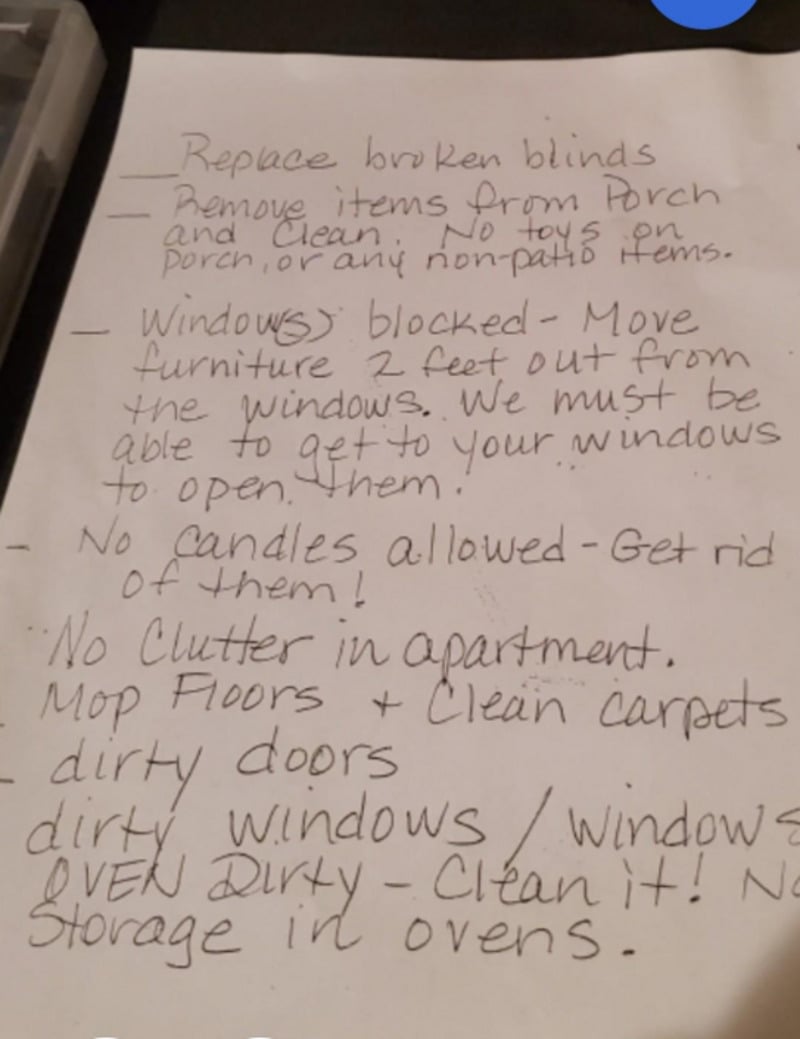 A handwritten to-do list on white paper with tasks such as replacing broken blinds, removing porch items, moving furniture from windows, banning candles, cleaning floors, carpets, windows, and ovens, and removing oven storage.