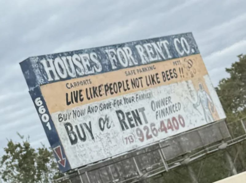 A weathered roadside billboard reads, “Houses for Rent Co. Live like people not like bees!! Buy or Rent. Owner financed. 713-926-4400,” with faded illustrations and trees in the background.