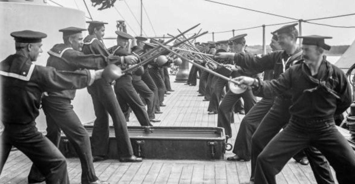 A group of sailors in uniform practice fencing with swords on the deck of a ship, lined up in pairs facing each other.