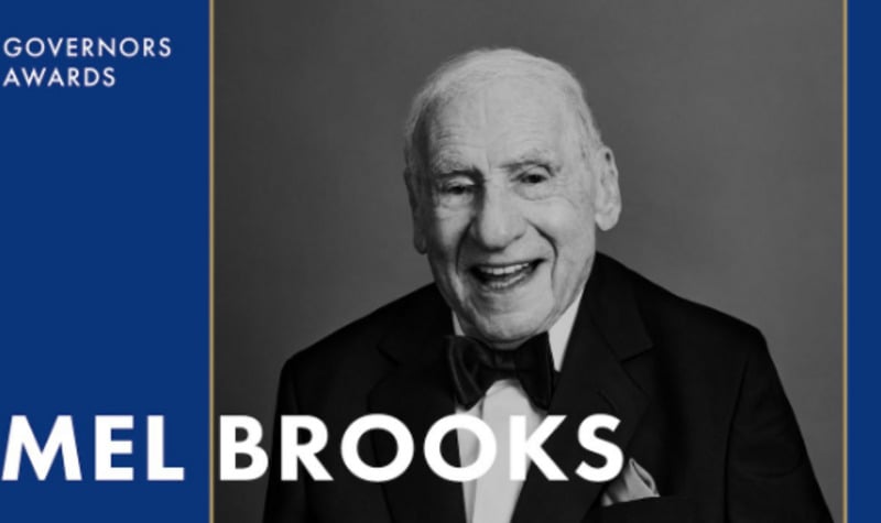 Black and white photo of an older man in a tuxedo smiling, with text reading "Governors Awards" and "Mel Brooks" on a blue and gold background.
