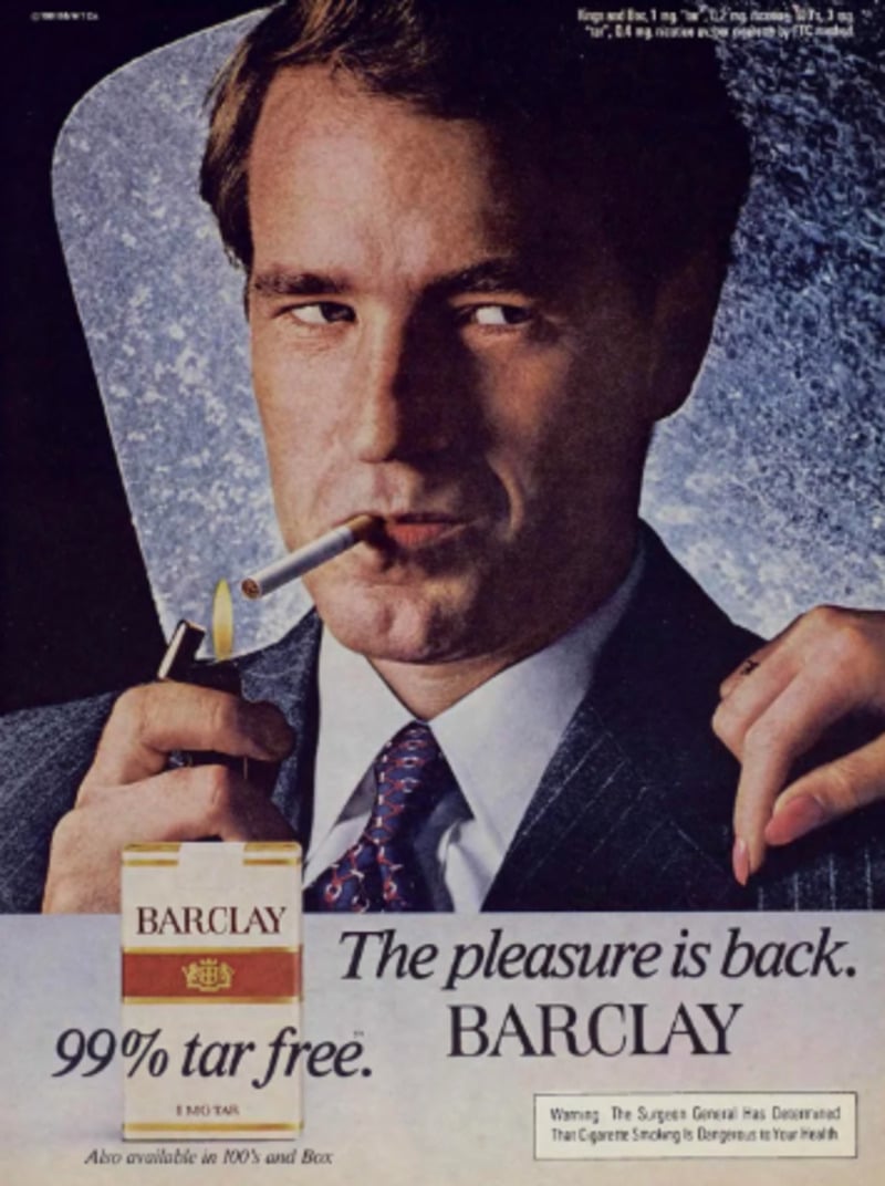 A well-dressed man in a suit holds a lit cigarette and looks at the camera. Below him is a pack of Barclay cigarettes with the text "The pleasure is back. BARCLAY. 99% tar free." and a surgeon general warning.