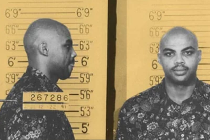 A mugshot of a man with a shaved head wearing a patterned shirt, shown in both profile and front view against a height measurement background. The date and identification number are visible on the left.