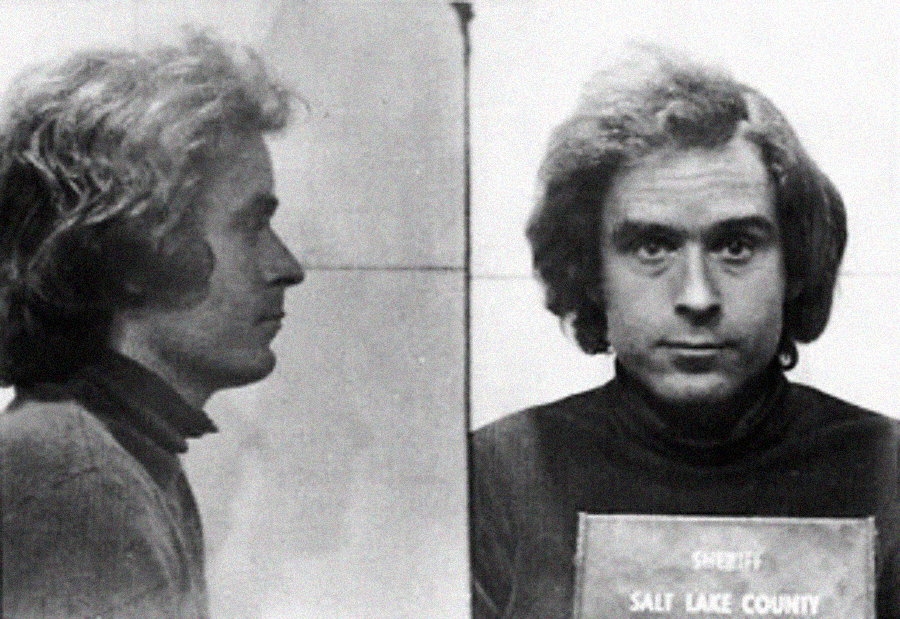 Black and white mugshot showing a man with medium-length wavy hair. The left view is a side profile; the right view shows his face as he looks at the camera, holding a sign that reads "Sheriff Salt Lake County.