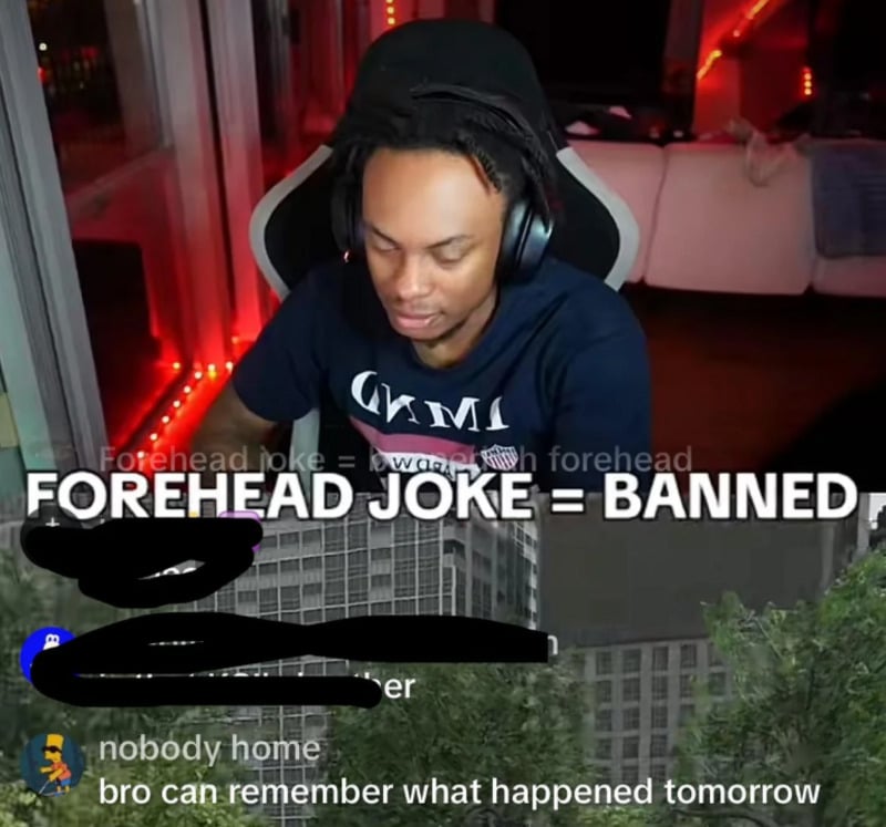 A man with dreadlocks wearing a headset sits at a desk, playing a game. Text overlay reads "FOREHEAD JOKE = BANNED." A comment at the bottom says, "bro can remember what happened tomorrow.