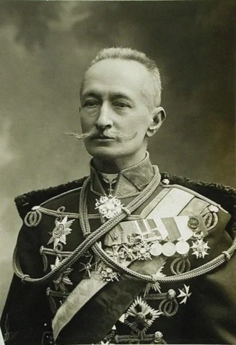 A distinguished man in a military uniform decorated with medals, sashes, and ornate cords, with a prominent mustache and short-cropped hair, posing for a formal portrait.