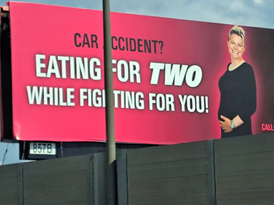 A billboard with a pregnant woman smiling, next to bold text that reads: "Car Accident? Eating for TWO While Fighting for YOU!" The background is pink and red, with contact information partially visible.