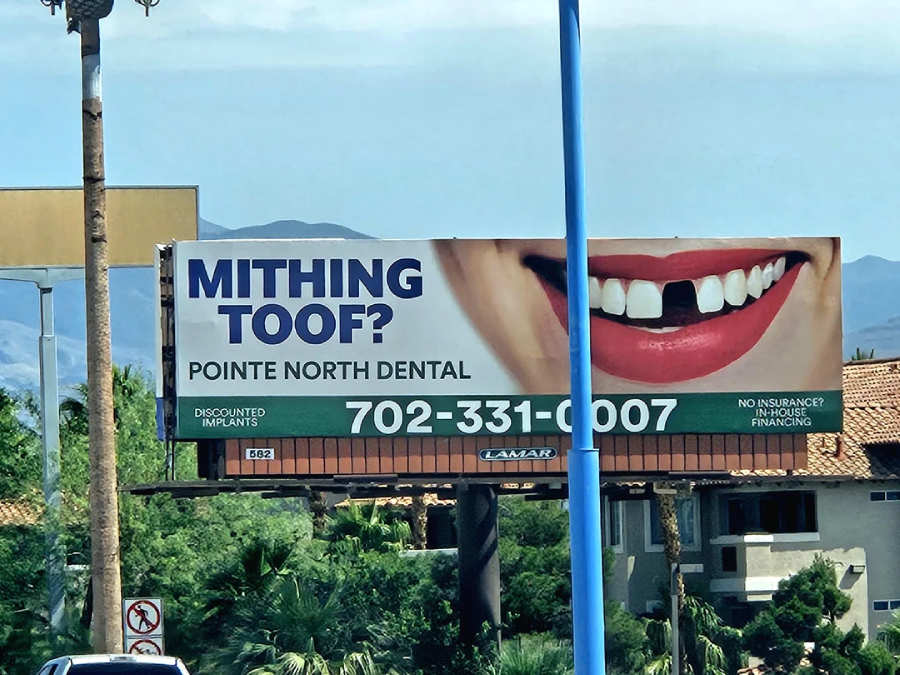 A billboard for Pointe North Dental shows a large smiling mouth with a missing front tooth and the text "MITHING TOOF?" along with a phone number and information about discounted implants and insurance financing.