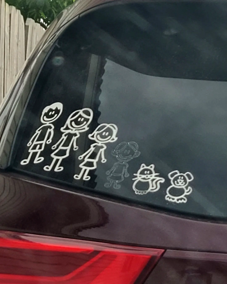 White stick figure decals on a car window show two adults, two children, a smaller child, a cat, and a mouse, representing a family with three kids and two pets.