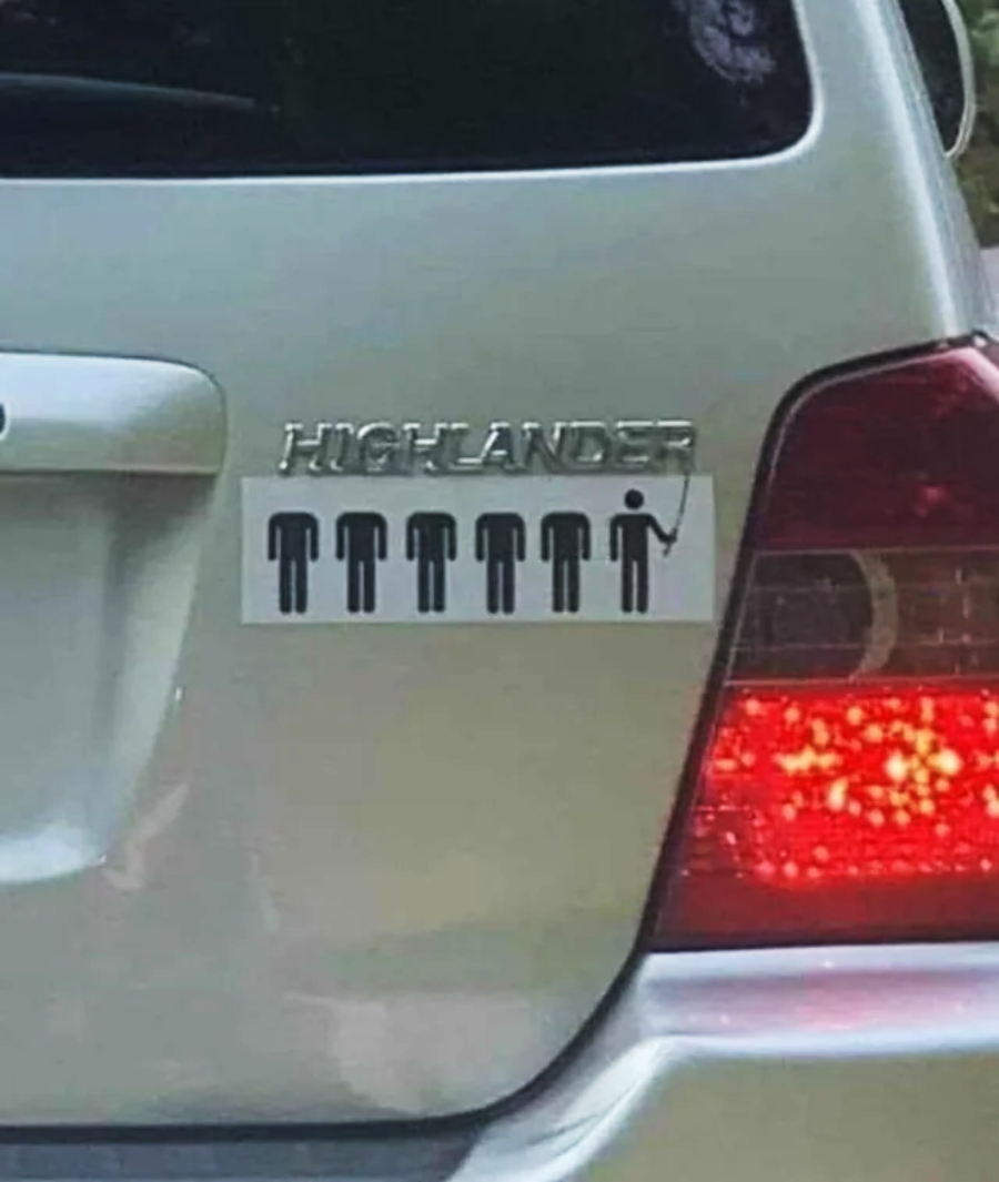 A car with the "Highlander" badge has a sticker showing five stick figures, with the last one holding a sword, referencing the phrase, "There can be only one," from the Highlander series.