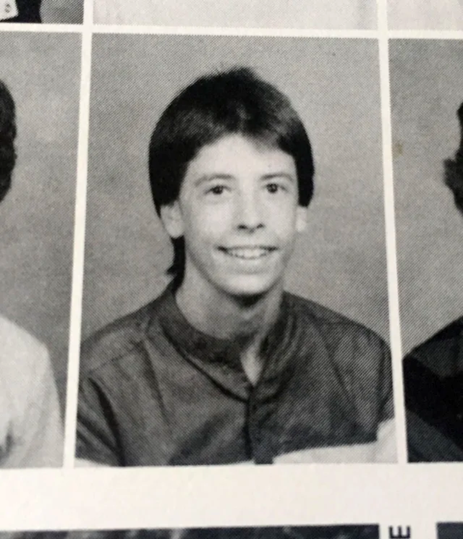 Black and white yearbook photo of a young person with short dark hair, wearing a buttoned shirt, smiling at the camera against a plain background.